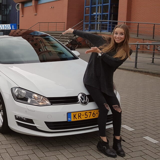 Geslaagde leerling bij de lesauto van Hofstad Rijopleiding, bij het CBR in Rijswijk